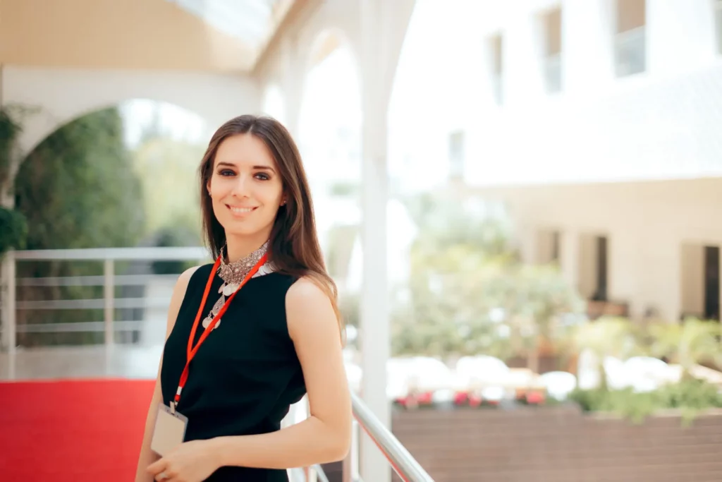 Hostess sorridente all'ingresso di una sala congressi