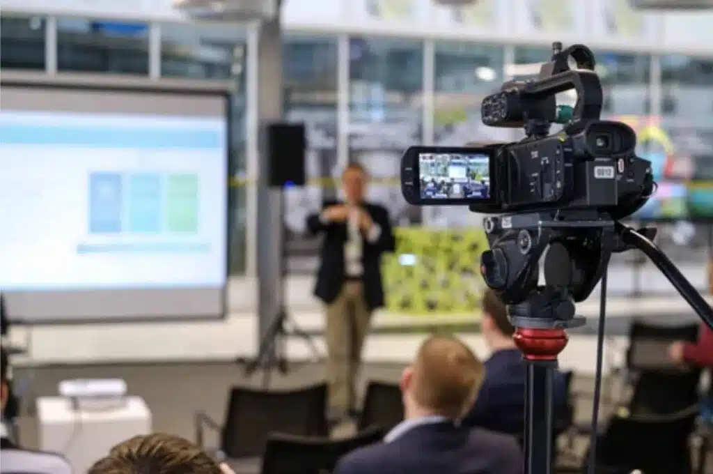 Videocamera che riprende un relatore durante una conferenza